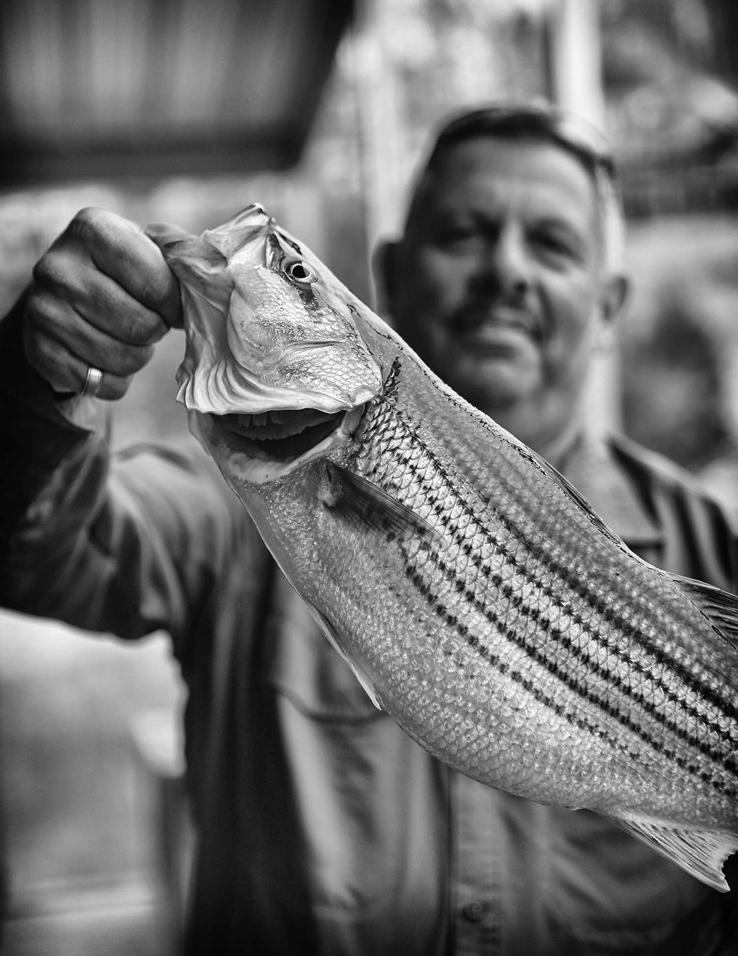 Randy Corbitt of Cincinnati, Ohio, holds up a striper fish after his annual fishing trip on Norris Lake with his son, RJ. photo by Kellie Ward - 2019