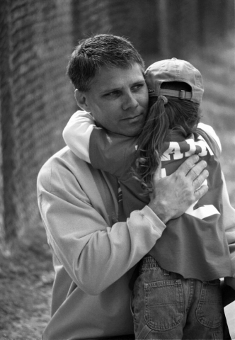 Clint Bane gives his daughter, Brooke, a hug before she goes to bat. photo by Alison Church - 2001
