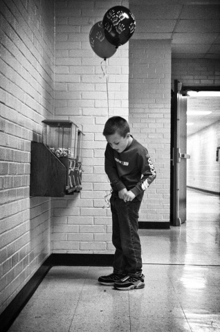 Balloons and candy - what more could a kid want? Kindergartener Seth Pebley digs for change in the hallway of Valley View Elementary. Photo by Jessica White - 2003