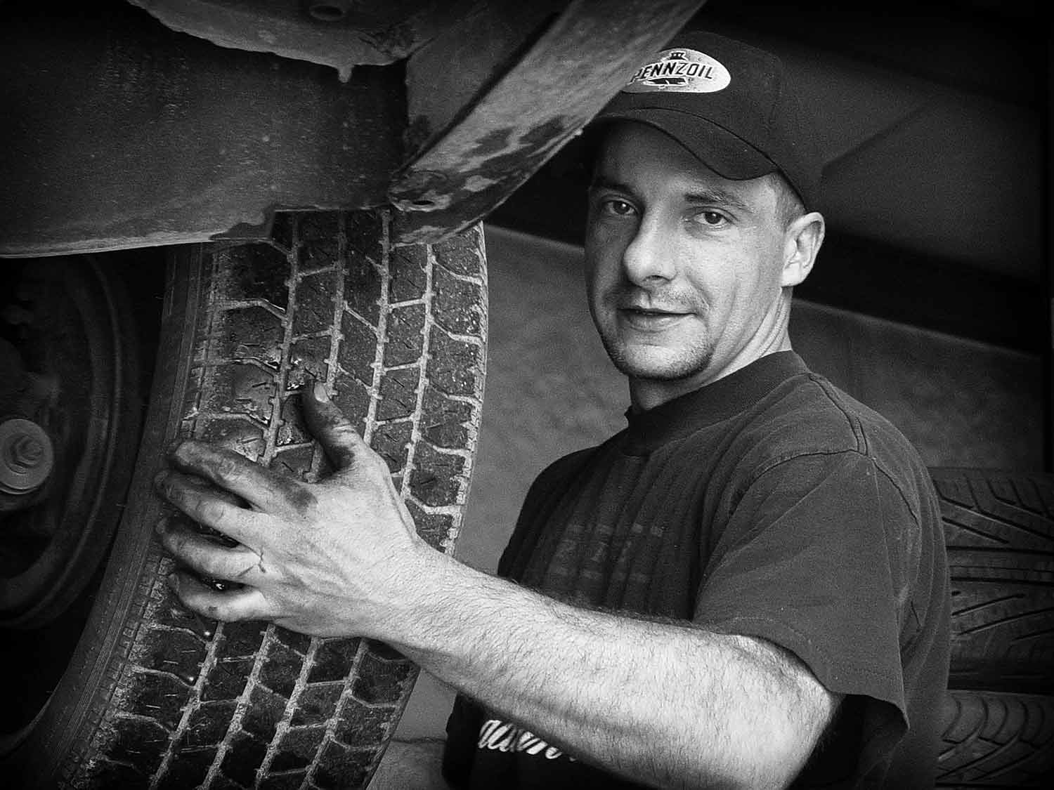 John Womble removes tires from a car at Minton’s Tire Service. Photo by Kristi Davis - 2006