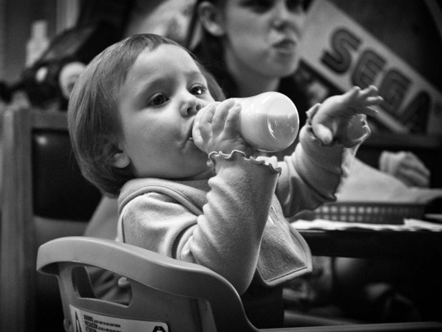 1-year-old Ryleigh Weltch drinks from her cup while admiring customers in Charley’s Pizza. Photo By Demetric Banahene. - 2008