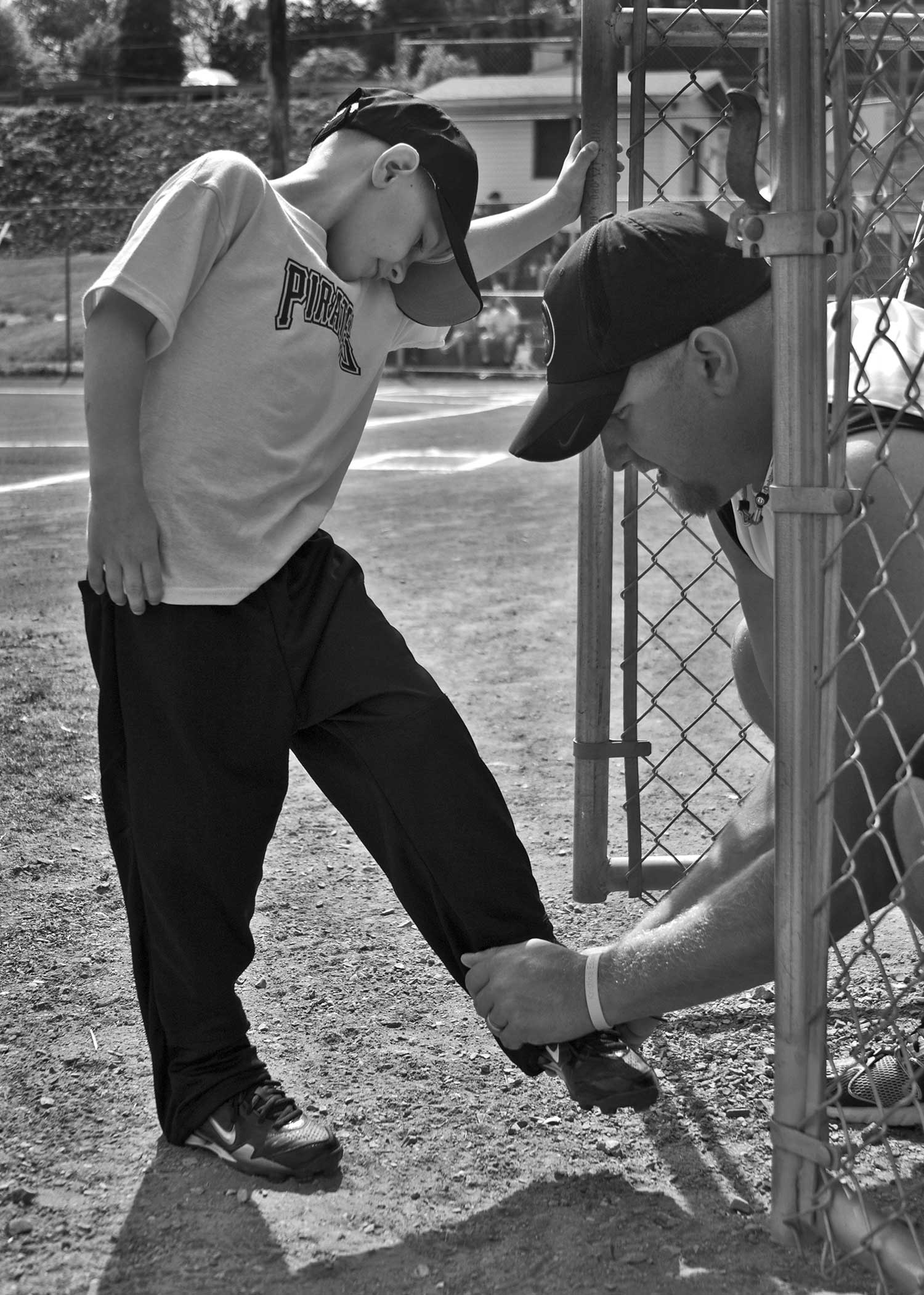 Rick Berry (right) helps his son Landon Berry (left) get ready for his little league baseball game. photo by Stephanie Myers - 2010