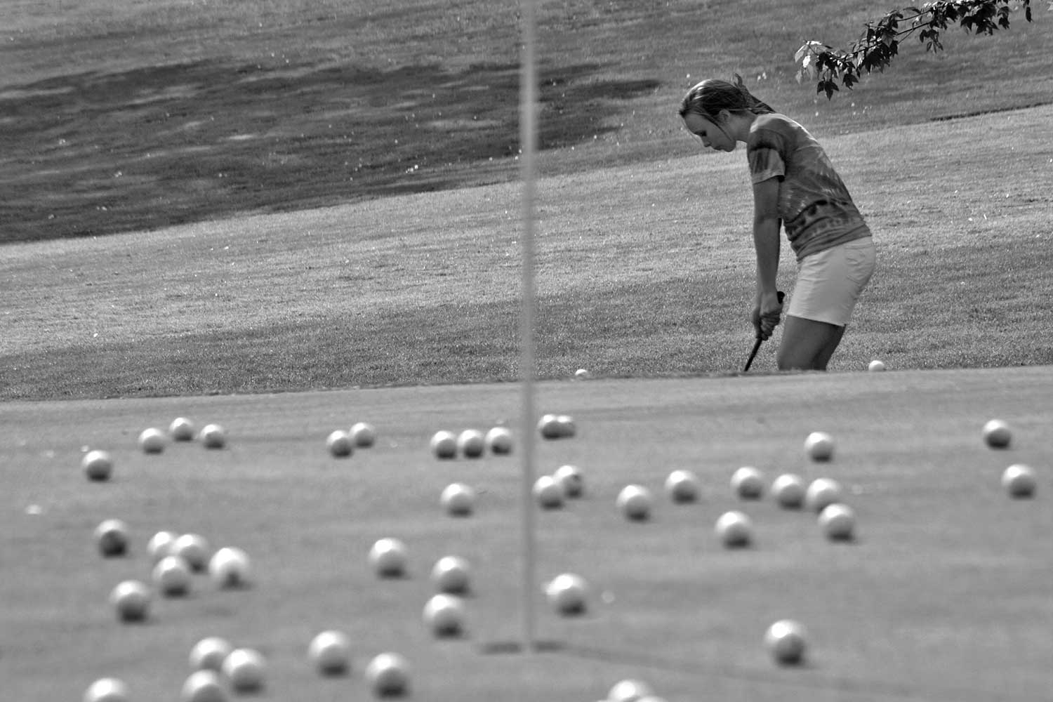 Lindsay Taylor attempts a chip shot at the green. photo by Andy Hayes - 2010