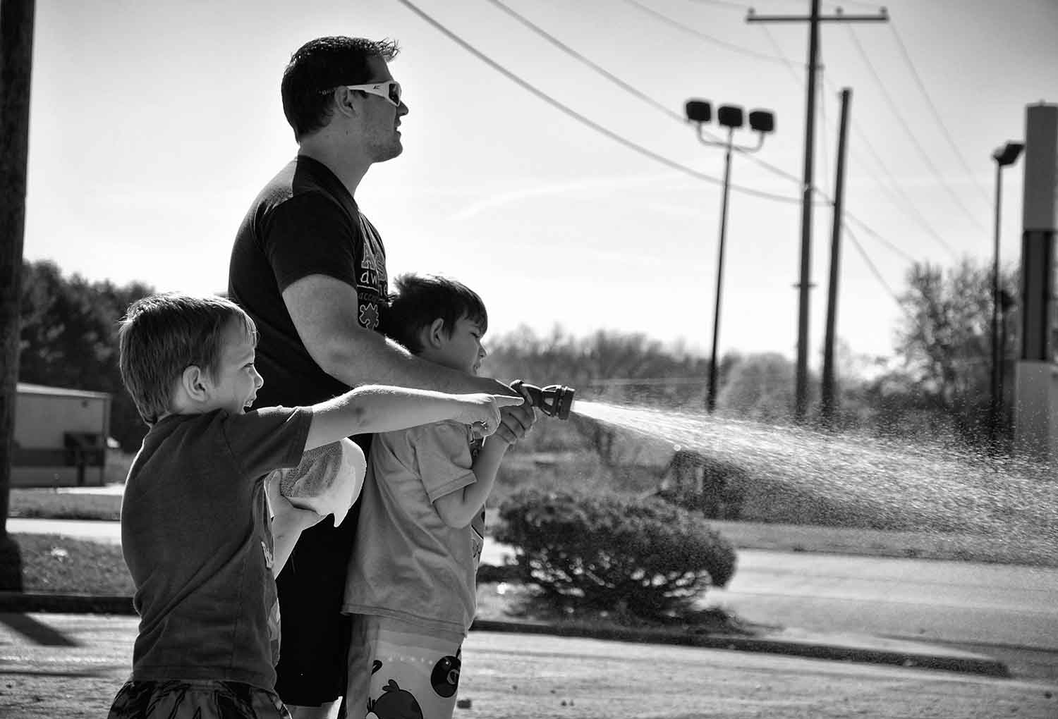 Landon and Noah Francis help their dad Jesse rinse off a car during an Autism Awareness event. photo by Molly Morgan - 2013