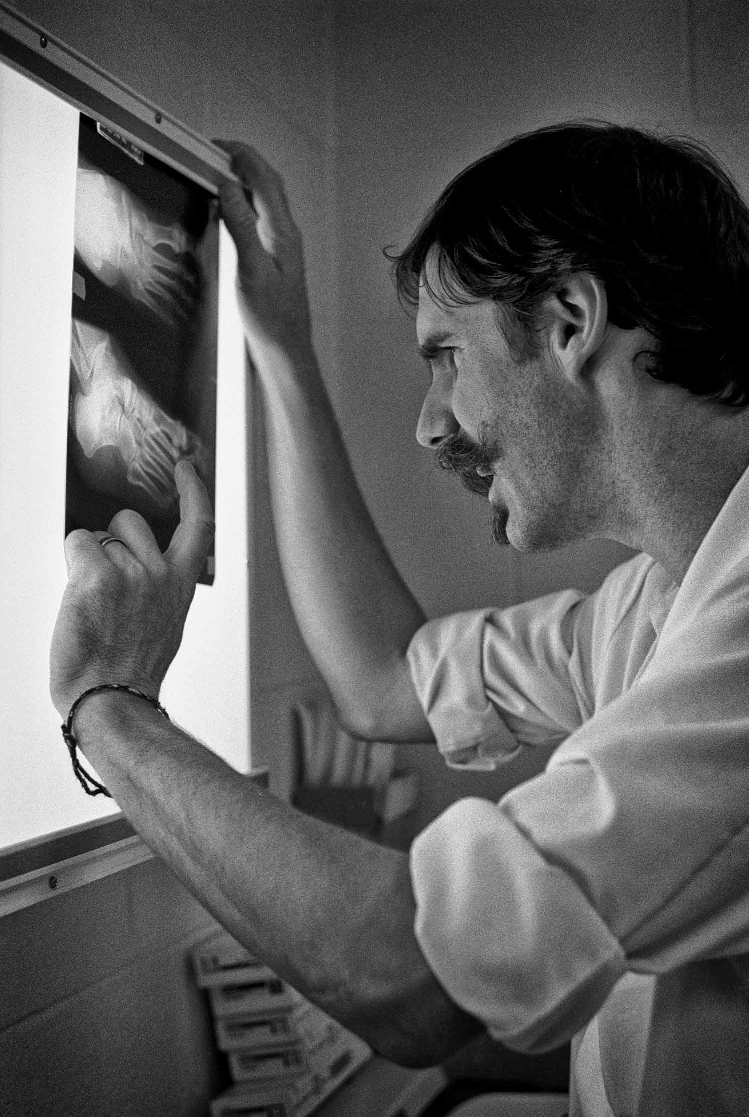 In the hospital emergency room,Dr. John Pillow studies an x-ray of a possible fracture. Photo by Carol Morgan - 1995
