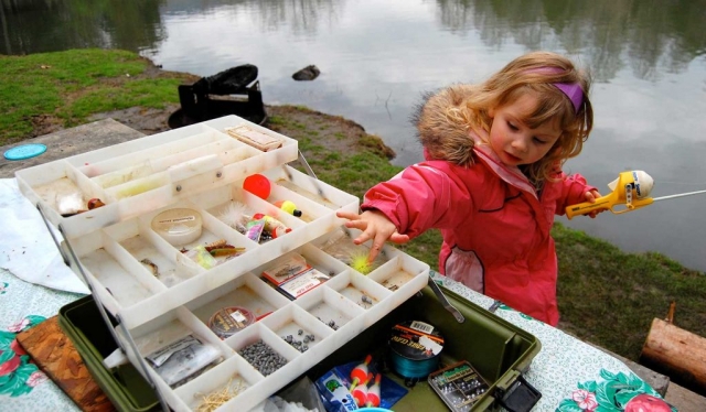 Isabella Ball, 3, examines a fishing lure while camping at Cove Lake State Park. photo by Jordan Vest - 2009