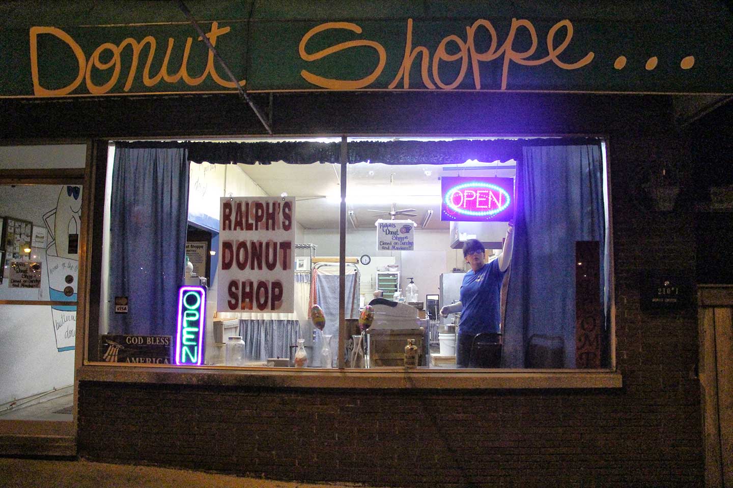 The clock strikes 4:30 a.m. as two student photographers emerge from the morning dusk to greet Tina Baird. Baird has agreed to give her guests the chance to view life through her eyes as she opens her donut shoppe.  photo by Olivia Johnson - 2017