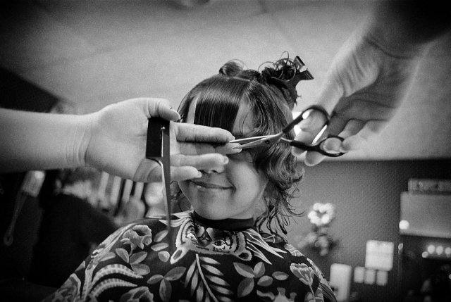 Waiting patiently for the finished look, Felicia Muse’s eyes are temporarily hidden behind the stylist’s shears. Photo by Boris Cibej - 1995